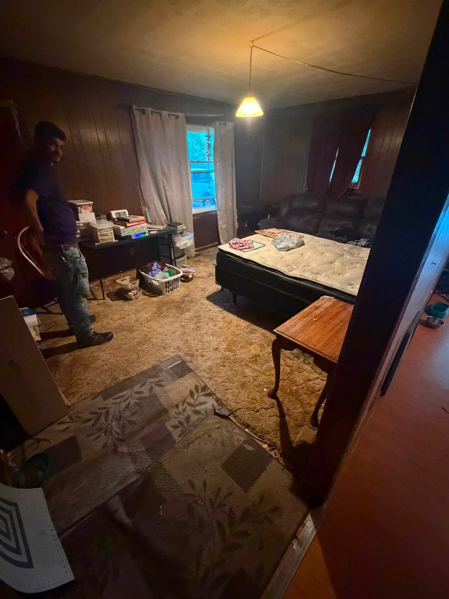 Bedroom full of furniture and boxes before cleanout